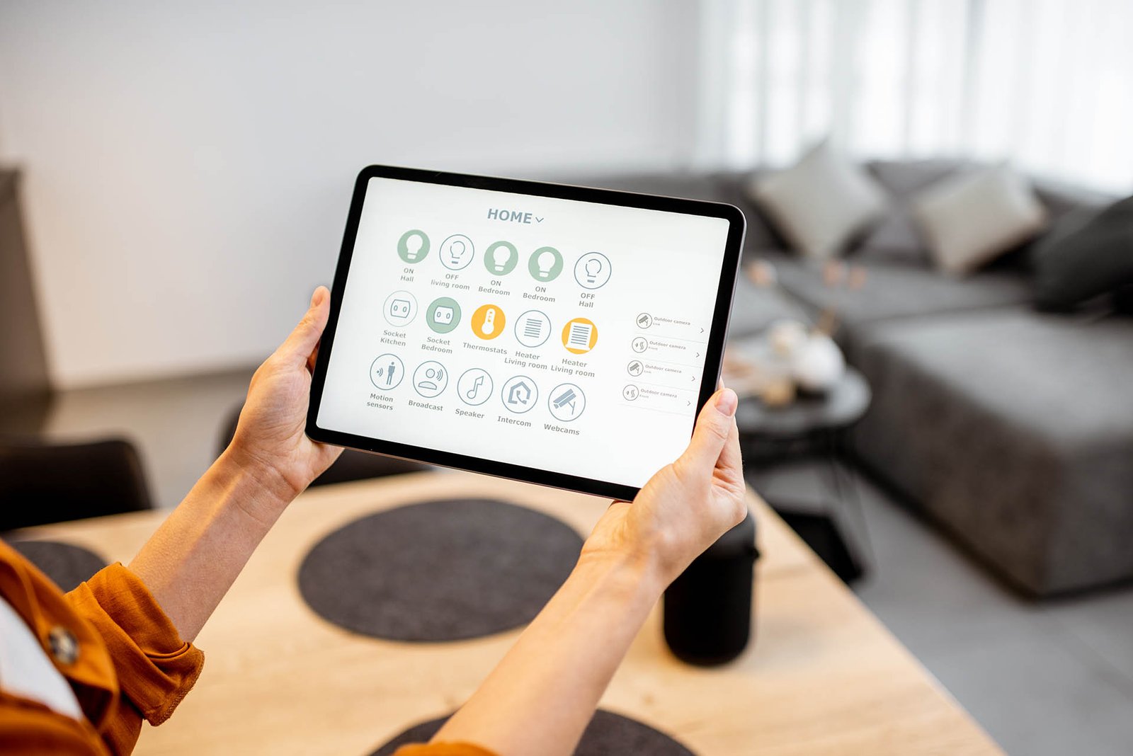 Woman controlling smart devices with a digital tablet at home
